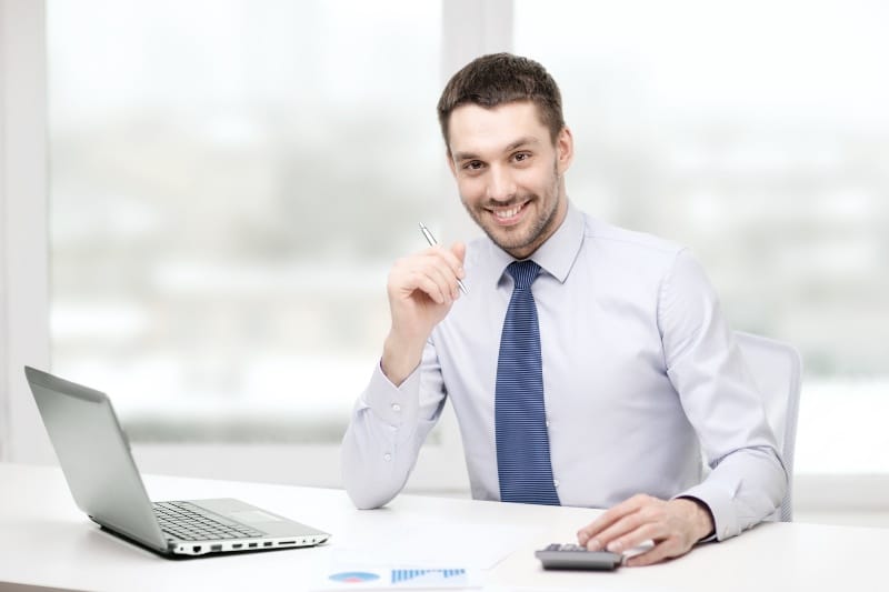 Man holding a pen and calculator to work on bookkeeping for small business